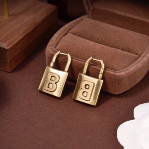 Balenciaga Brass Lock Earrings In Gold